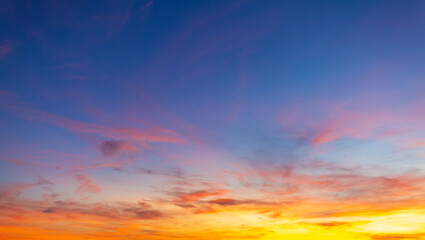 Fototapeta premium Beautiful sunset sky background with vibrant orange, pink, and blue colors,Breathtaking panoramic view of a dramatic sunset sky, featuring a stunning gradient of deep blue to fiery orange and soft.