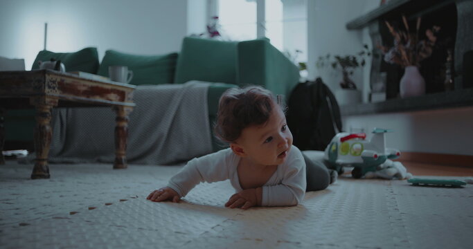 Baby lying on play mat lifting head and chest, practicing early motor coordination and neck strength during tummy time in softly lit living room