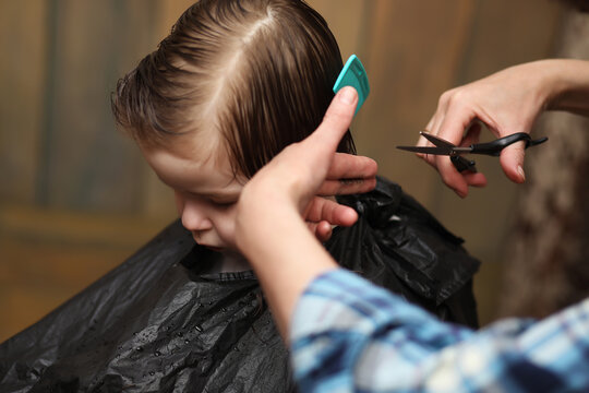 A little boy is trimmed in the hairdresser's bright emotions on face