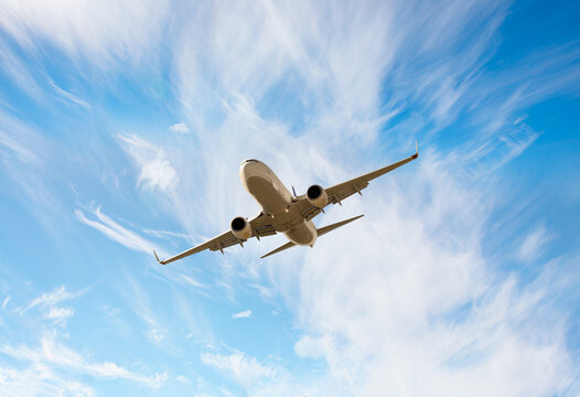 White passenger airplane flying in the sky amazing clouds in the background - An airplane shakes during turbulence flying air hole - A plane spinning in round clouds - Front view of an airplane 