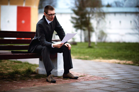 A man in a suit lies on a brick floor