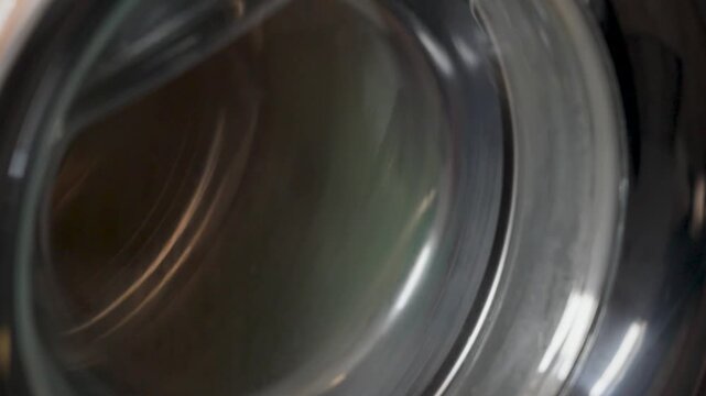 washing machine spin cycle close up, rotating drum background for laundry automation and home appliance concept