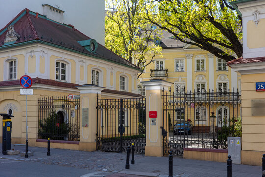WARSAW, MAZOWIECKIE, POLAND - APRIL 23 2026: A sun-drenched view of the historic Branicki Palace outbuilding and ornate gates under a clear spring sky.