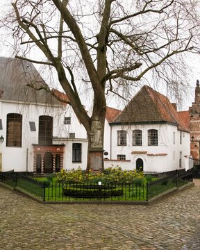 Groot begijnhof mechelen, belgium with statue and old tree