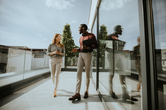 Business discussion on balcony of modern building in the afternoon sun