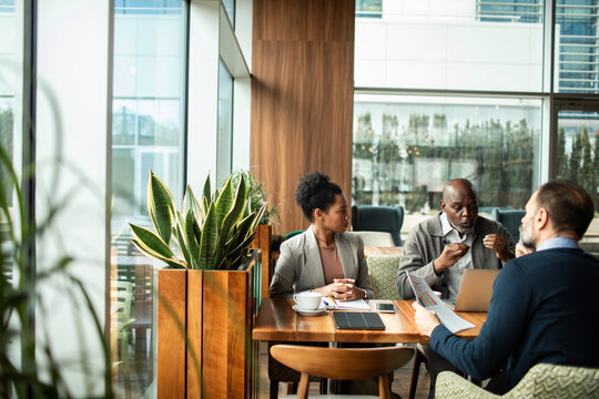 Diverse business team meeting in modern cafe lounge