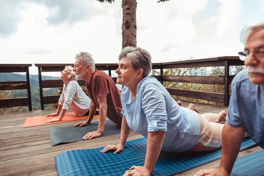 Older adults practicing yoga on mountain deck