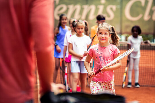 Children at tennis lesson on outdoor clay court