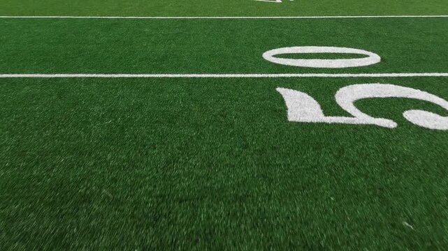 American football field low POV flyover showing yard lines and hash marks