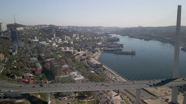 Aerial view of Vladivostok showing Zolotoy bridge , Zolotoy bay (Golden bay),roads, sea, residential buildings, and docks.