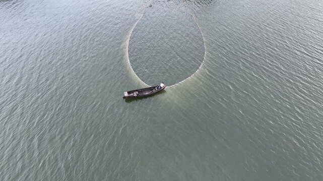 A perfect circle of tradition: local fishermen cast their wide nets across the serene waters of Kaptai Lake in Rangamati.