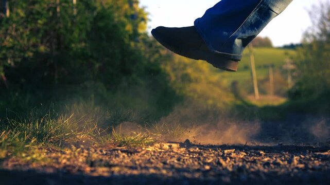Feet kicking up dust on road