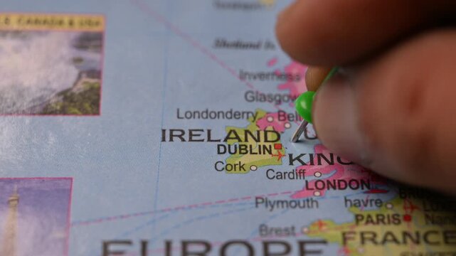 Close-Up World Map Shot Featuring Green Pin Highlighting Ireland Pointed by Hand 4K 60fps