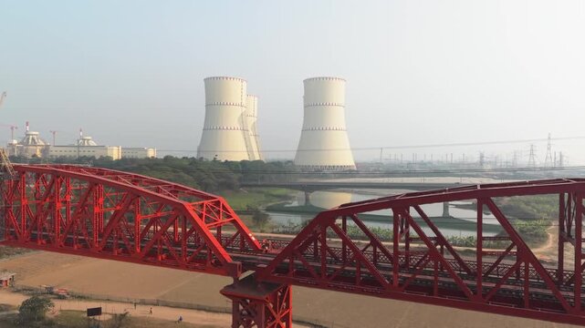 Red bridge with cooling towers in background