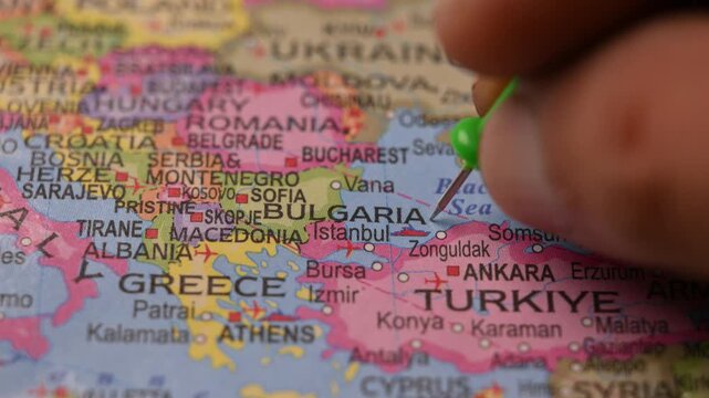 Close-Up World Map Shot Featuring Green Pin Highlighting Bulgaria Pointed by Hand 4K 60fps
