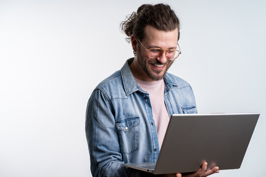 Happy freelancer coder using laptop while working isolated in studio