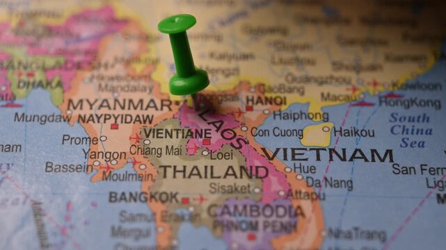 Close-Up World Map Shot Featuring Green Pin Highlighting Laos Pointed by Hand 4K 60fps