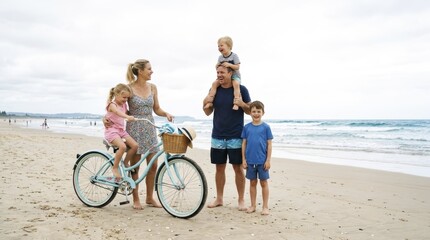 Fototapeta premium Family with children and bicycle having fun on the beach in summer