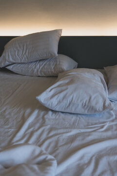 Soft pillows on comfortable bed.Empty bedroom, pillow, blanket and white linen after wake up. The crease of an unmade bed sheet in the bedroom after night sleep and wake up in the morning time.