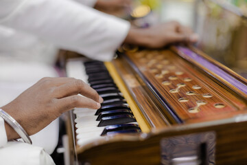 Obraz premium Musician Play Traditional Instrument, Hands on Keys, Cultural Performance, Artistic Expression, Music Session, Keyboard Detail, Indoor Event