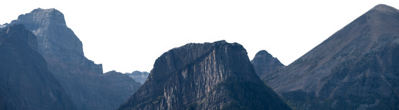 Rocky blue mountain peaks with sunlit highlights under a clear sky showcasing rugged terrain, natural landscape beauty, and dramatic alpine scenery.