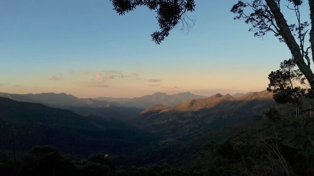 Panorama a&eacute;reo das montanhas de Minas Gerais com luz dourada do p&ocirc;r do sol destacando o relevo e a vegeta&ccedil;&atilde;o da Serra da Mantiqueira.