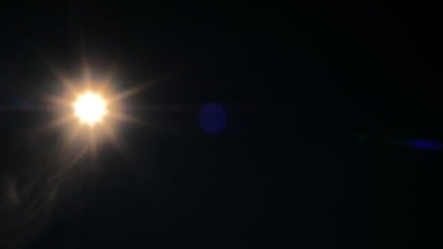 Bright star shines bold against velvet night sky. Lens flare glows with warm, radiant light. Darkness frames star's brilliance, pure and clear. Perfect for cinematic night scenes or cosmic themes