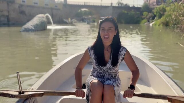 Latin woman paddling canoe on Segura River in Murcia, Spain, smiling and enjoying summer afternoon, travel lifestyle and freedom concept