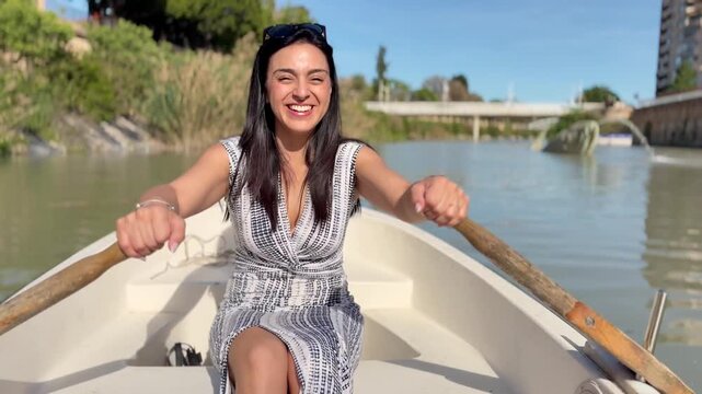 Latin woman paddling canoe on Segura River in Murcia, Spain, smiling and enjoying summer afternoon, travel lifestyle and freedom concept