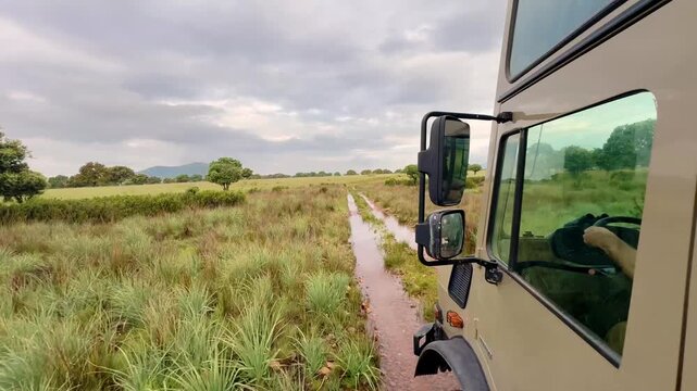 4x4 off road vehicle driving through mud puddles in Caba&ntilde;eros National Park, wildlife safari style adventure in Spanish nature