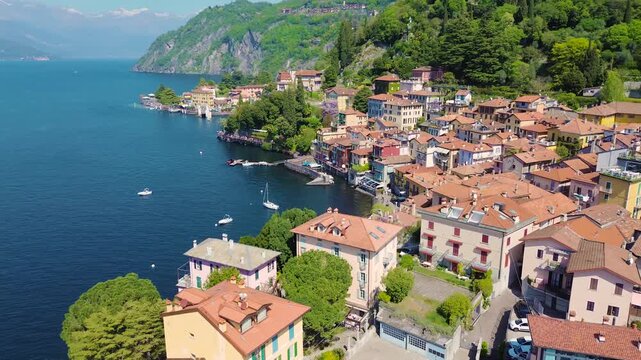 Aerial drone view of Varenna colorful houses on Lake Como coastline, scenic Italian village by water, travel destination Italy
