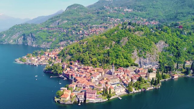 Aerial drone view of Varenna colorful houses on Lake Como coastline, scenic Italian village by water, travel destination Italy