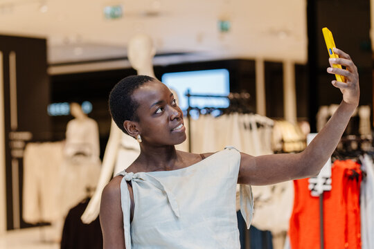 Close up shot of Happy Black Woman Taking Selfie with Shopping Bags in Store