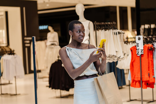 Stylish Happy Black Woman Taking Selfie with Smartphone in Fashion Boutique