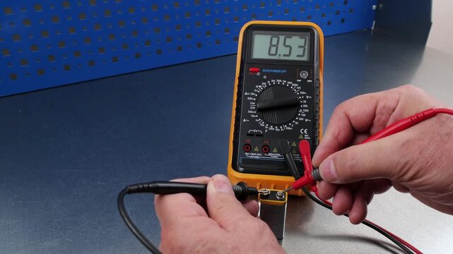 Measuring the voltage of alkaline batteries using a digital multimeter.