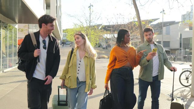A lively group of friends strolls happily together, each pulling their colorful suitcases and enjoying their time as they embark on a new adventure filled with excitement and joy.