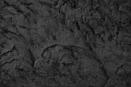 Dark textured stone surface with natural cracks