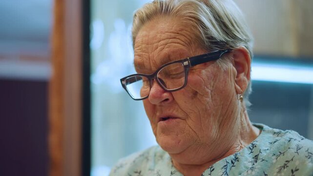 White grandma pausing midsentence, eyes closed behind glasses, soft window light, closeup portrait capturing memory and emotion, worn skin and thoughtful pause, reflective storytelling mood