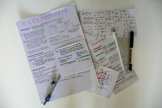 Handwritten study notes covering foundational chemistry and mathematics concepts on a home desk of a secondary school student preparing for GCSE exams or similar academic assessments. 