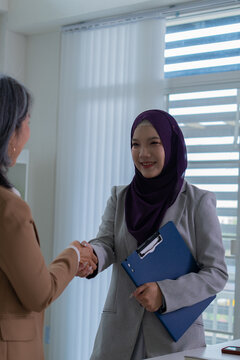 Muslim female applicant consulting with hiring manager in modern