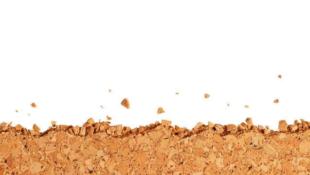 Crushed brown cork texture background with flying particles on black