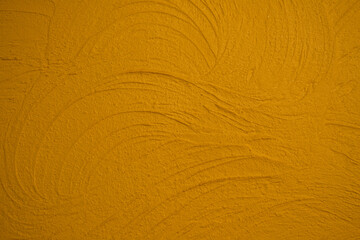 Textured yellow wall surface with swirling marks © reddish