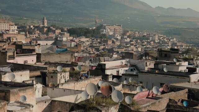 Scenic panoramic cityscape of the old medina of Fes, Morocco with mountains in the background during daytime
