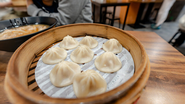 Taiwanese dumplings in bamboo basket on wooden table