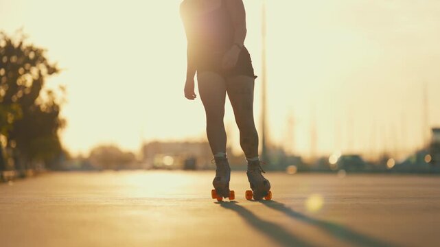 Silhouette of a woman roller skating during sunset