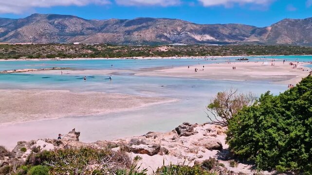High angle 4k panning of Elafonisi island with pink sand and turquoise water. view from dune to white beach, black volcanic rocks and endless blue lagoon. Scenic Crete Greece nature video.