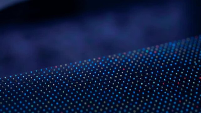 Close up of led screen surface with glowing pixel matrix. Abstract digital display technology. Pattern of red, green and blue light points for electronic node.