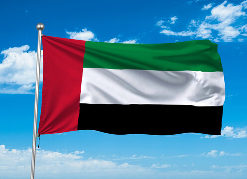 The national flag of the United Arab Emirates waving against a clear blue sky.