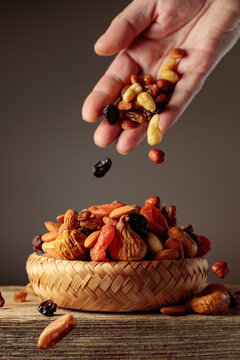 Mix of dried fruits is poured in a wicker bowl.