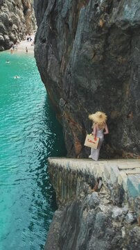 Woman with Hat Walking Down Steps to Turquoise Waters Mallorca